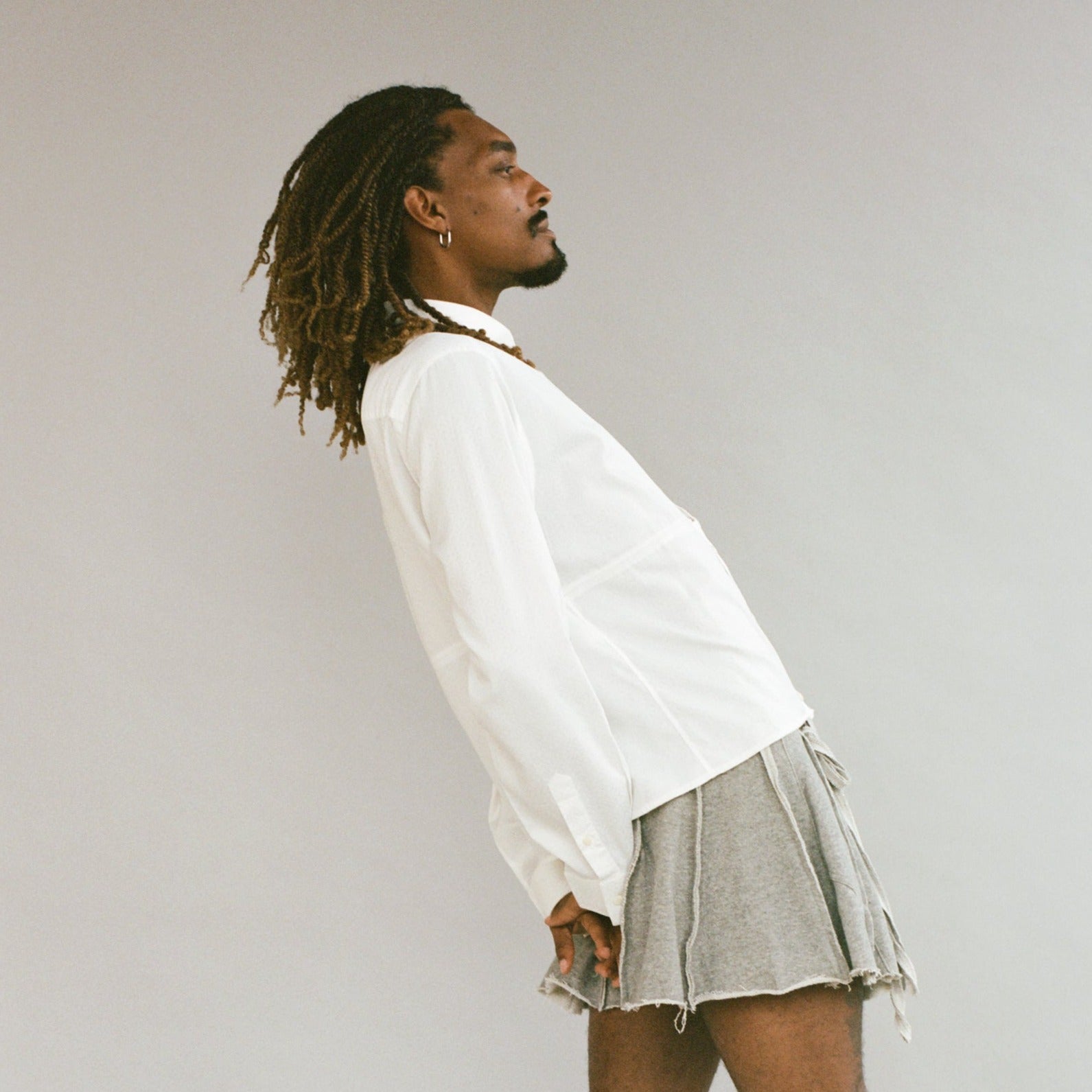 model wearing white button down turned to the side exposing their profile