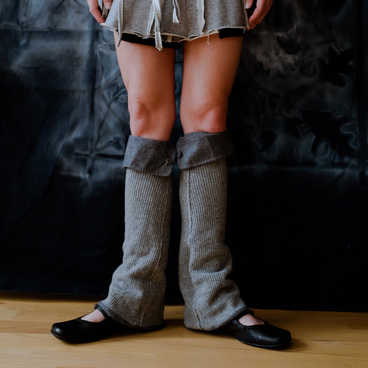 lower legs of a model wearing gray knit leg warmers with gray cuffed tops