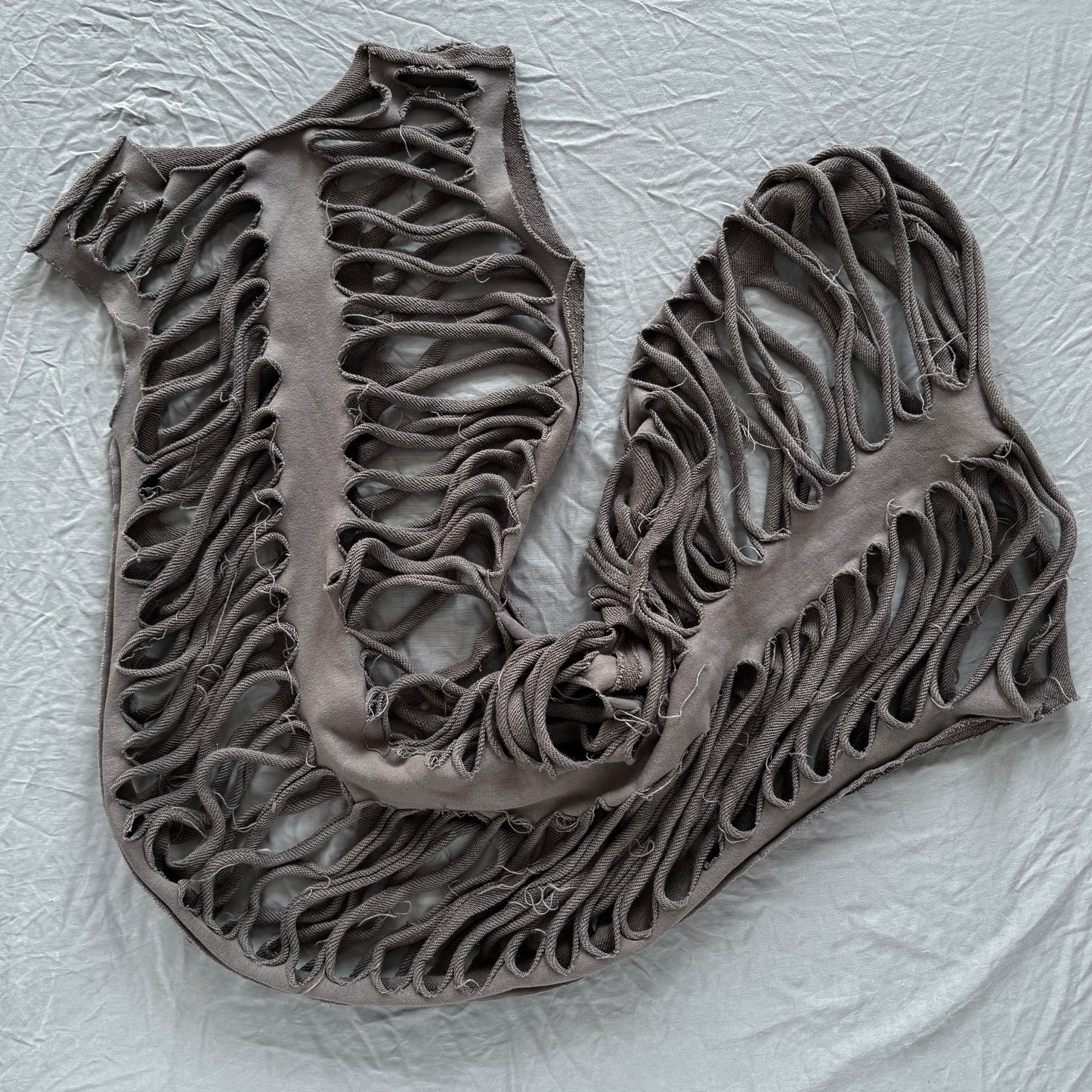 sliced ribs dress laid out on a gray backdrop with holes throughout looking like ribs