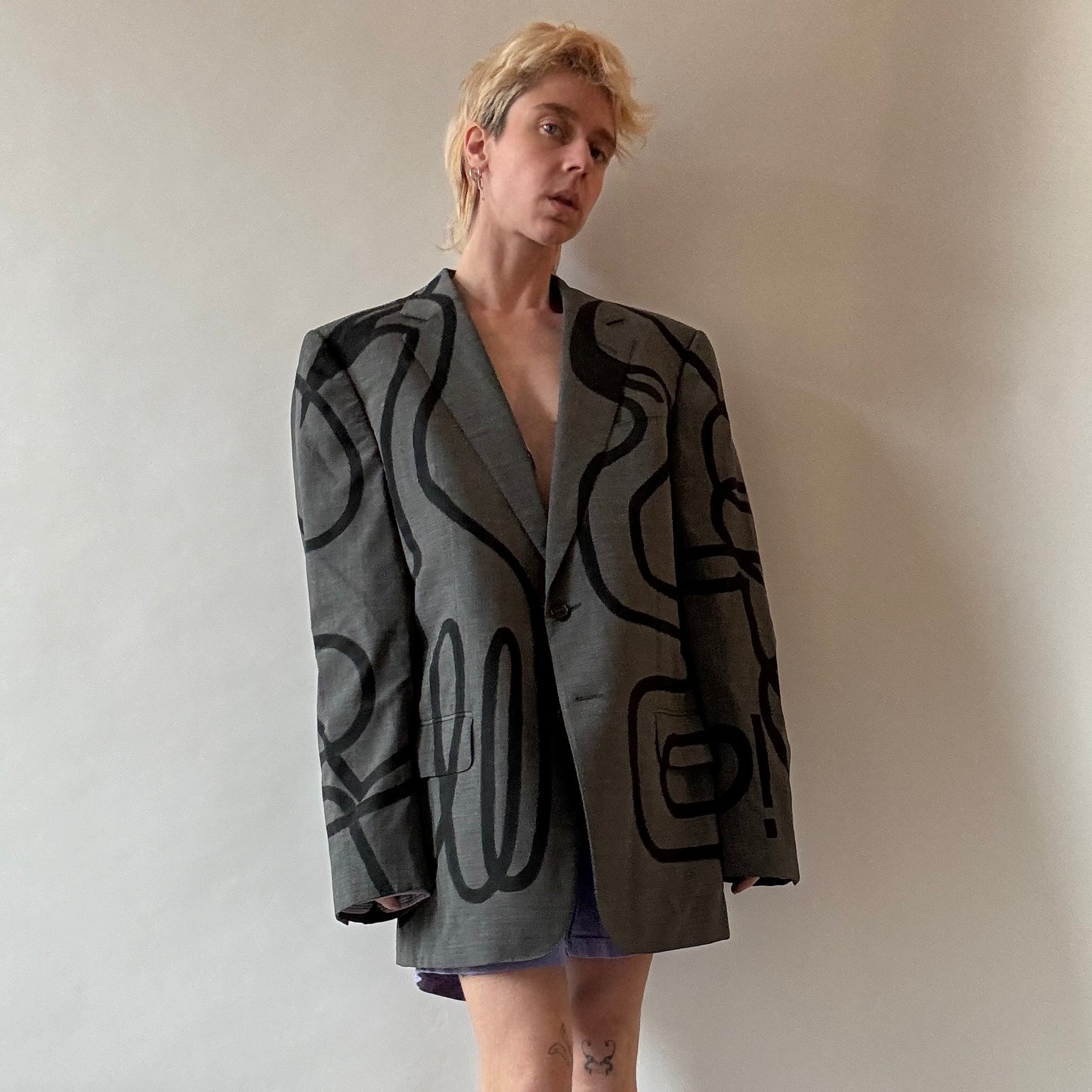 model wearing grey gucci blazer with black hand painted abstract swans across the front back and arms