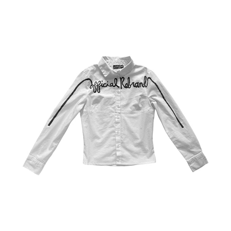 white button down top with hand painted text across the front reading official rebrand in black cursive