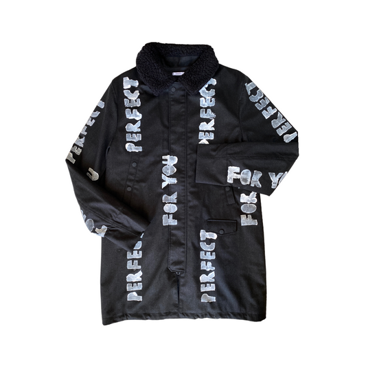 black long winter coat with faux shearling collar and white hand-painted stenciled PERFECT FOR YOU text across the front and arms