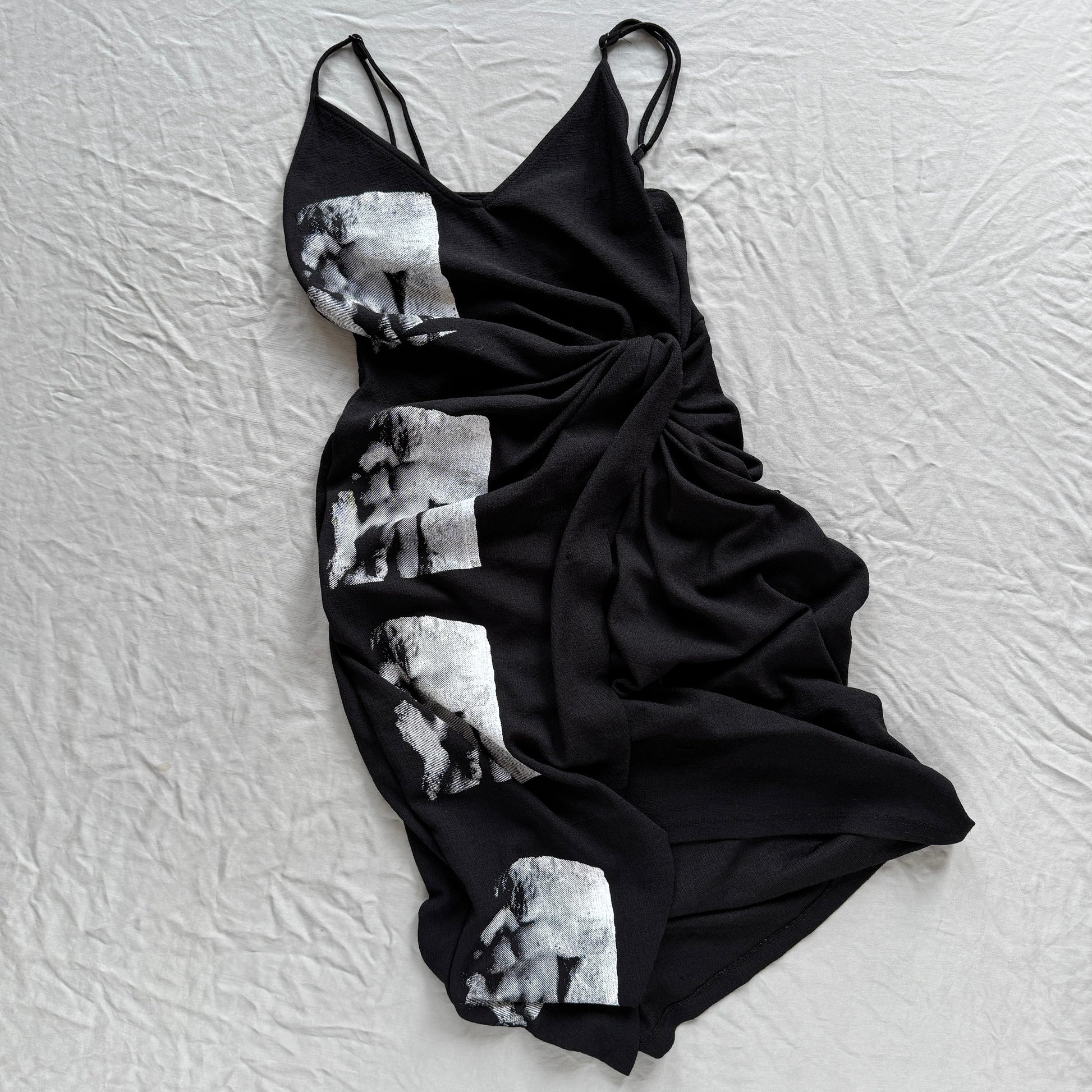 Black dress with white screen-printed michelangelo pattern on a textured white background