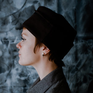 profile of model wearing a black cuffed cap