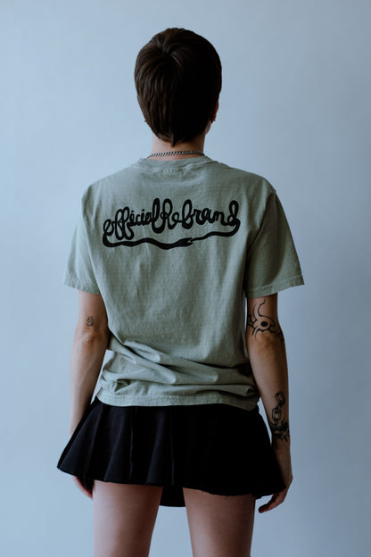 model facing away wearing a light green t-shirt with black ouroboros Official rebrand logo design on the back