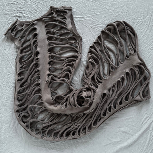 sliced ribs dress laid out on a gray backdrop with holes throughout looking like ribs