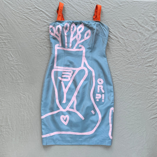 blue dress with bright orange adjustable spaghetti straps and a figure painted in pink holding a plant over their face and a heart on their thigh laid out on a gray background