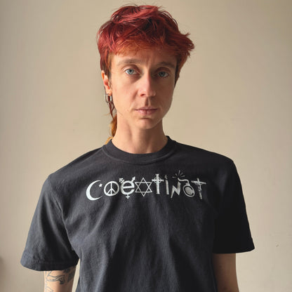 Person wearing a black t-shirt with white text against a plain background