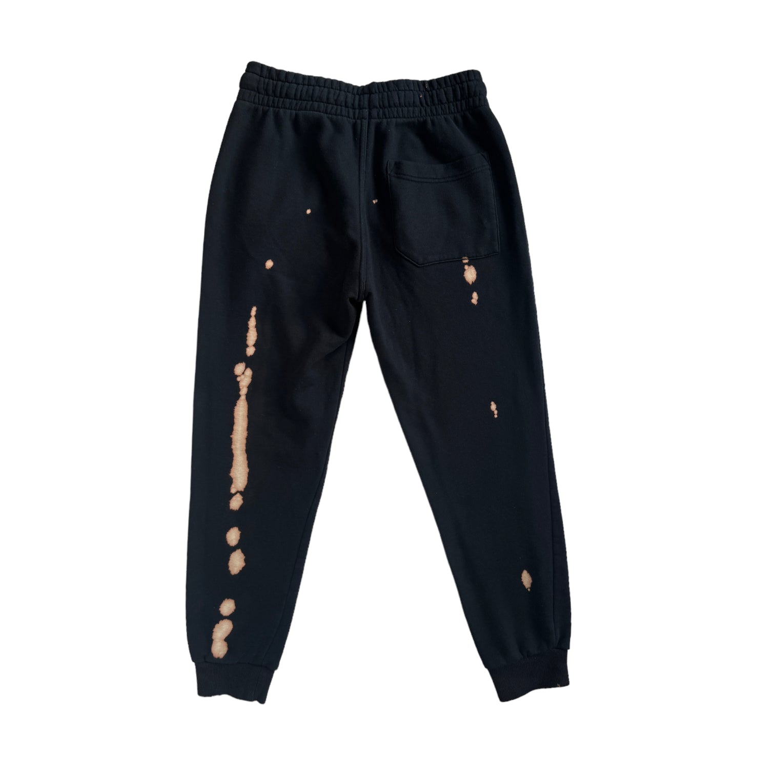 back of black sweatpants with bleach spots