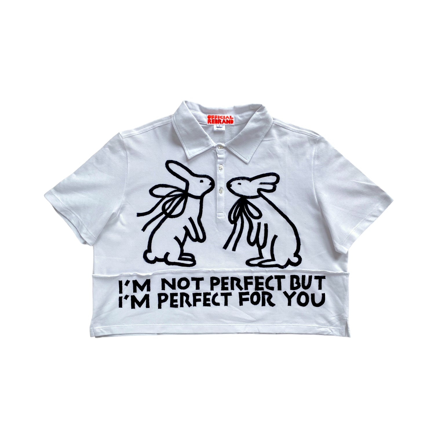 cropped white collared polo shirt with two black hand painted rabbits facing each other and black text reading I'M NOT PERFECT BUT I'M PERFECT FOR YOU