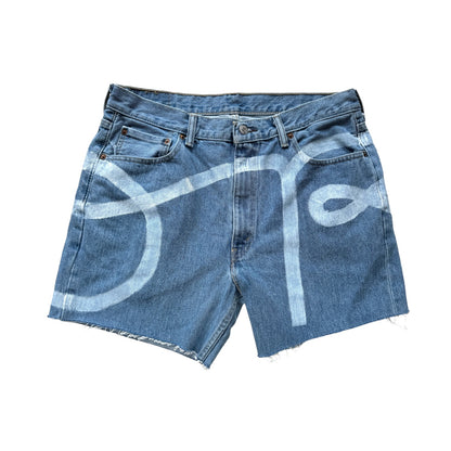 denim cut off jean shorts with cursive hand painted text reading OR stretching across the sides and front of the shorts