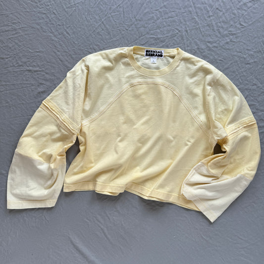 butter yellow custard colored long sleeve top shirt on a grey background