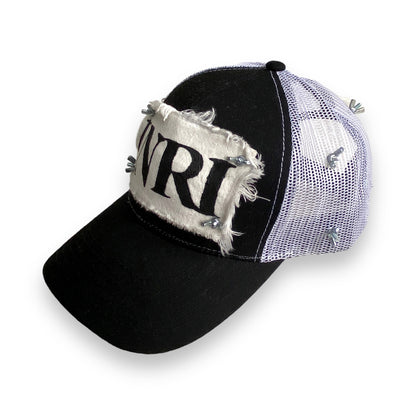 trucker hat with white mesh back, white patch with black INRI stamp, and nuts and bolts affixing the four corners of the patch to the front of the hat and wrapping around in a crown of thorns