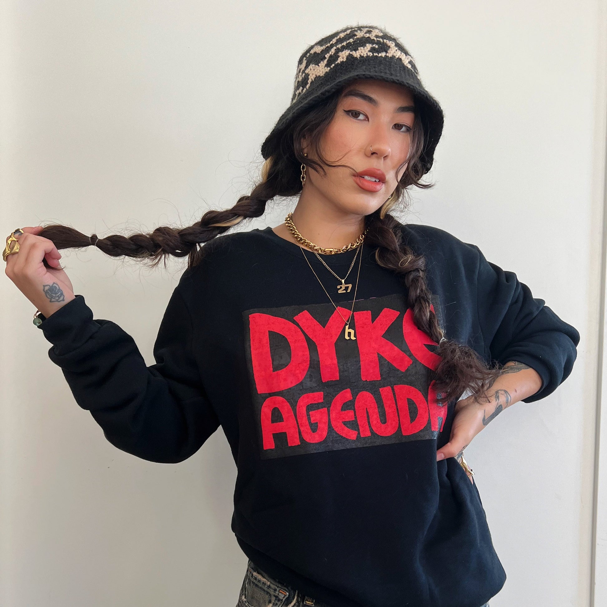 model HINA wearing black crew neck sweatshirt with red screen printed text reading DYKE AGENDA