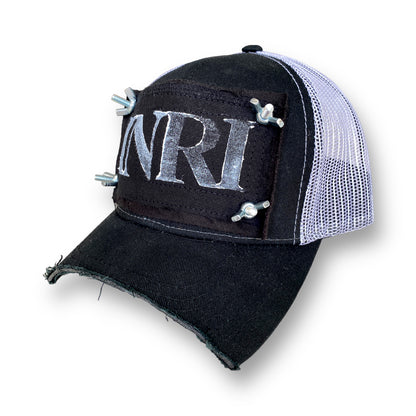 chopped brim trucker hat with white mesh back, black patch with white INRI stamp, and nuts and bolts affixing the four corners of the patch to the front of the hat