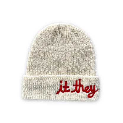white cream wool beanie with red cursive embroidery reading it they