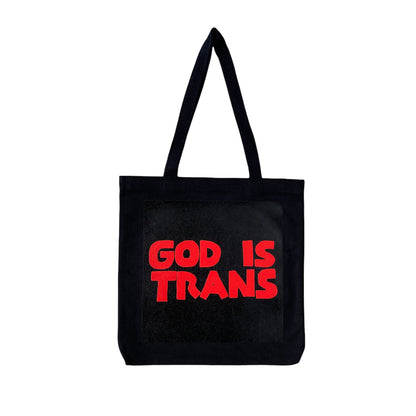 black tote bag with screen printed red text reading GOD IS TRANS