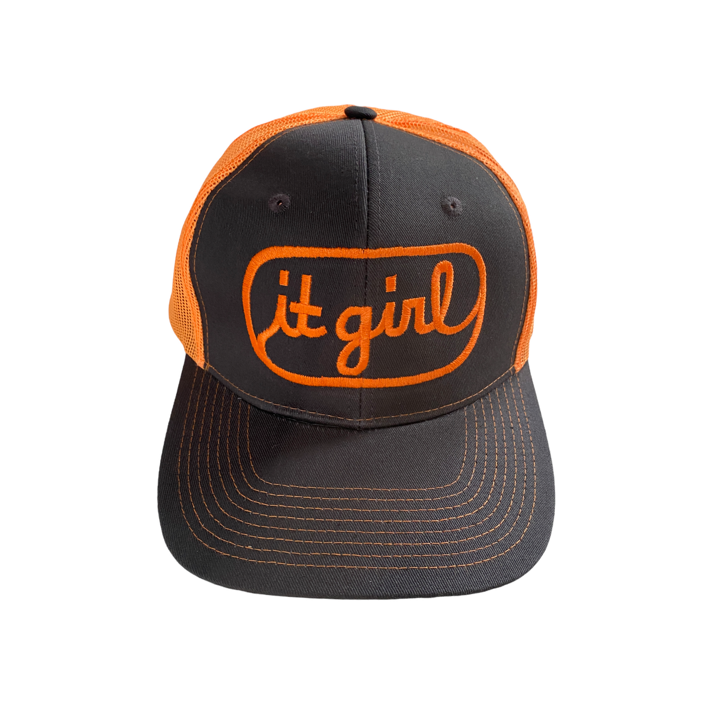 front of neon orange and stone gray trucker hat with orange embroidery reading it girl in cursive