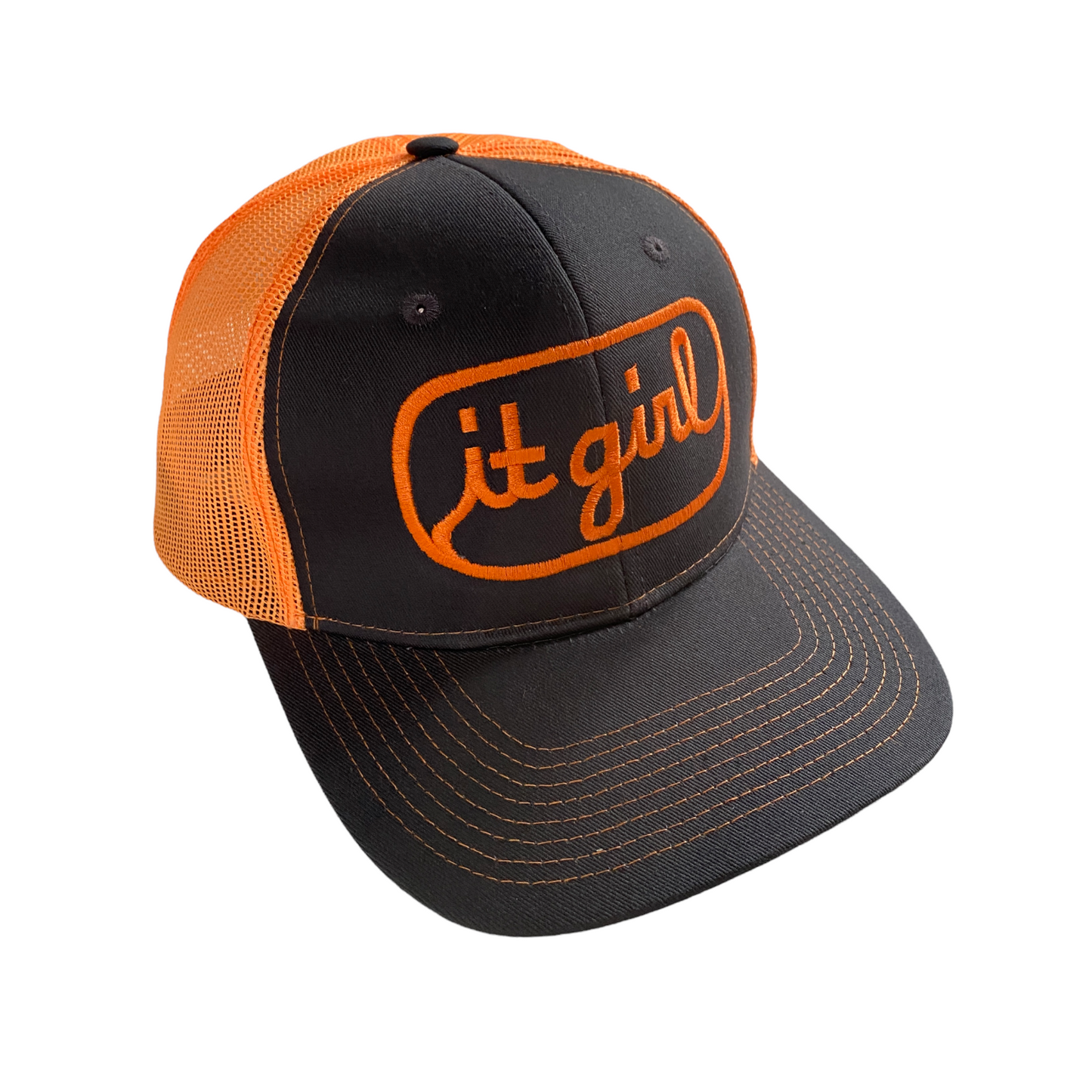 front of stone gray and neon orange trucker hat with orange embroidery reading it girl in cursive