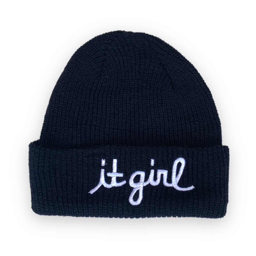 black wool beanie with white cursive embroidery reading it girl