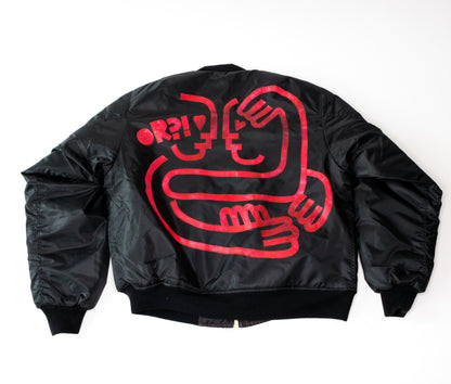 back of black bomber jacket with red hand-painted minimal design of two lovers embracing and text reading OR?!